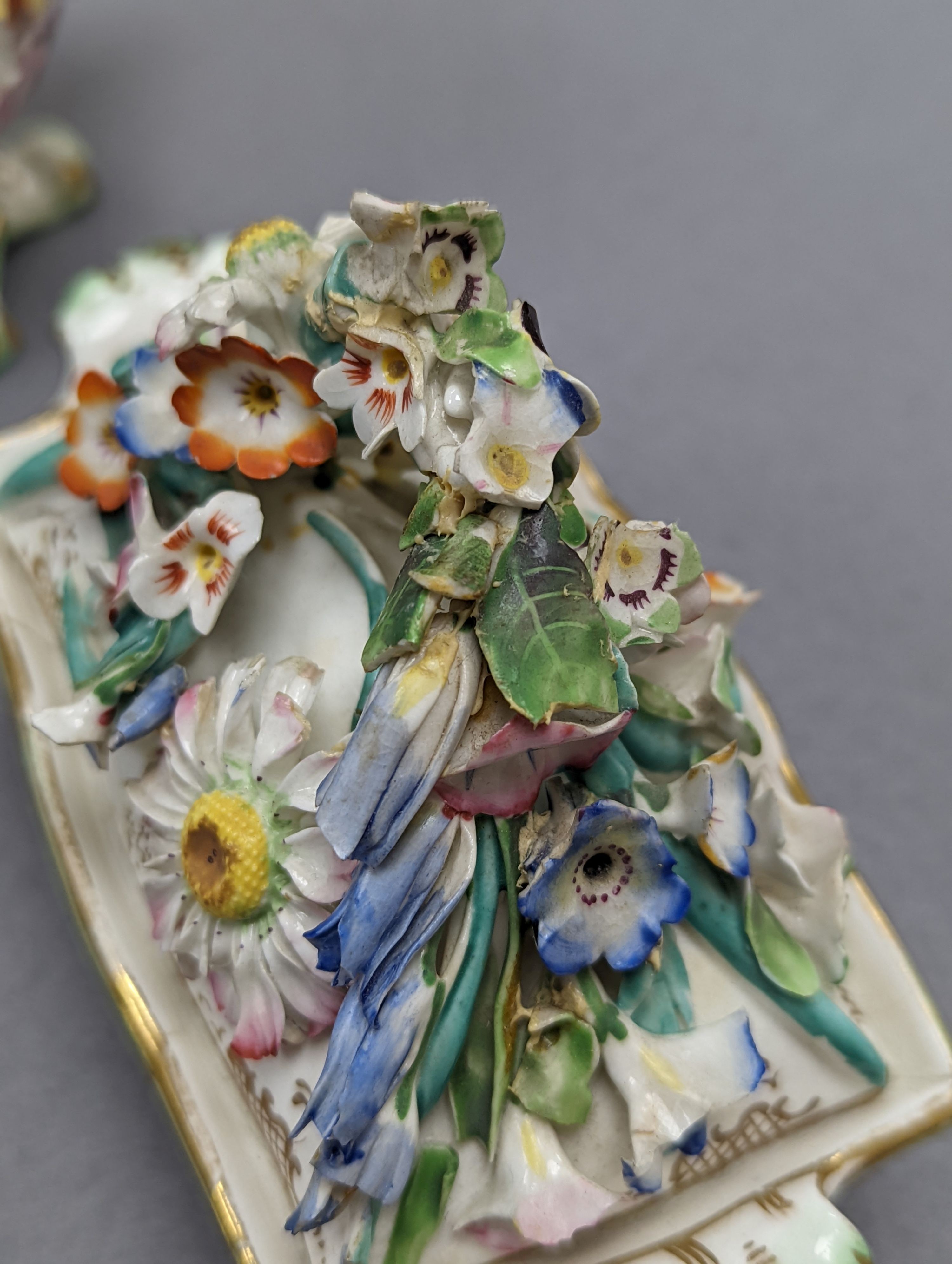 An 18th century Mennecy porcelain cup and cover, a Meissen style cup and cover, an English porcelain floral encrusted double inkwell and cover and a similar jar and cover